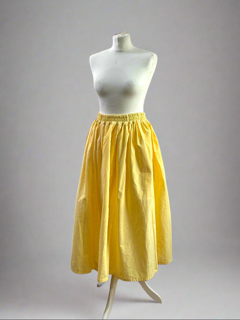 Yellow skirt on a mannequin against a gray background