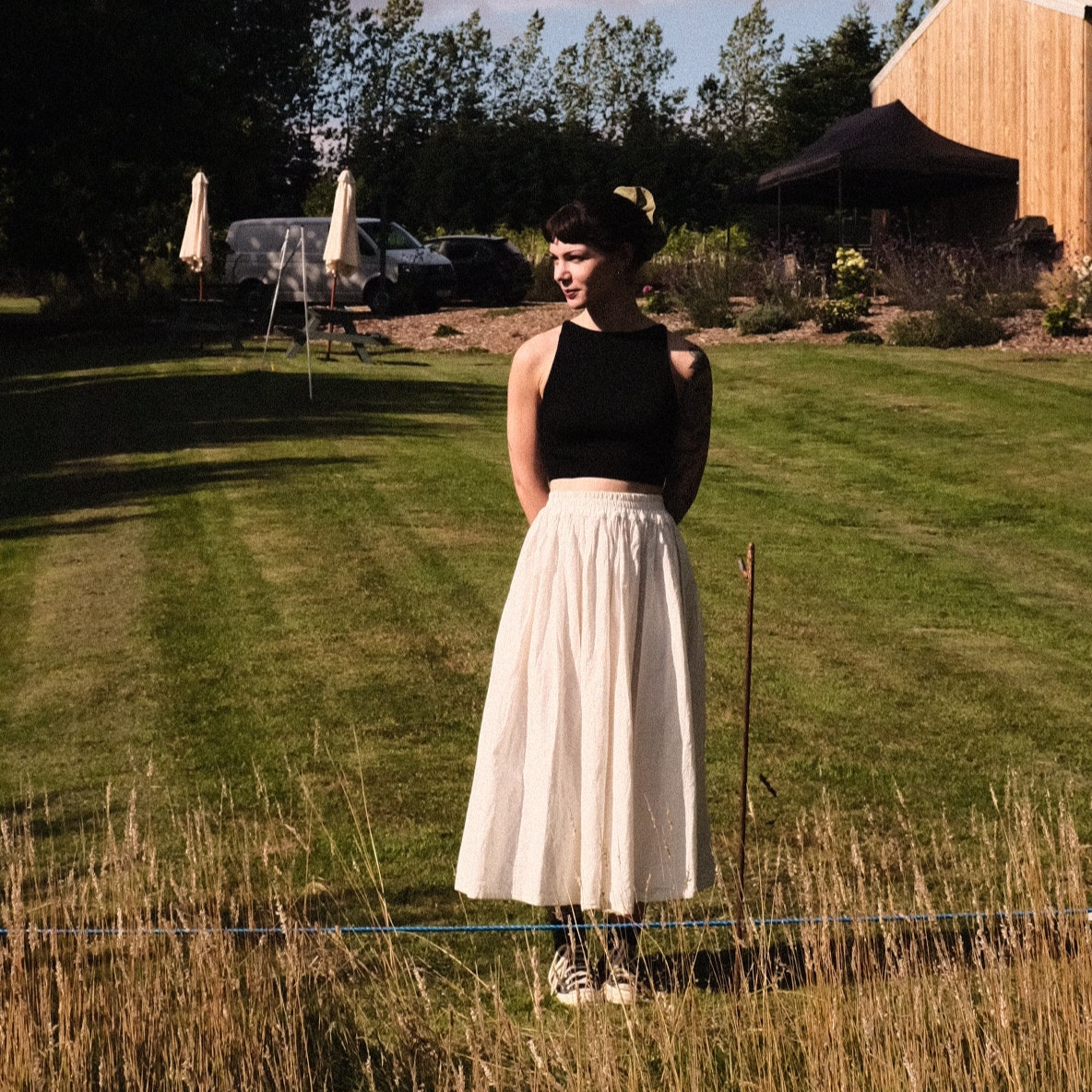 person wearing a white skirt in a field