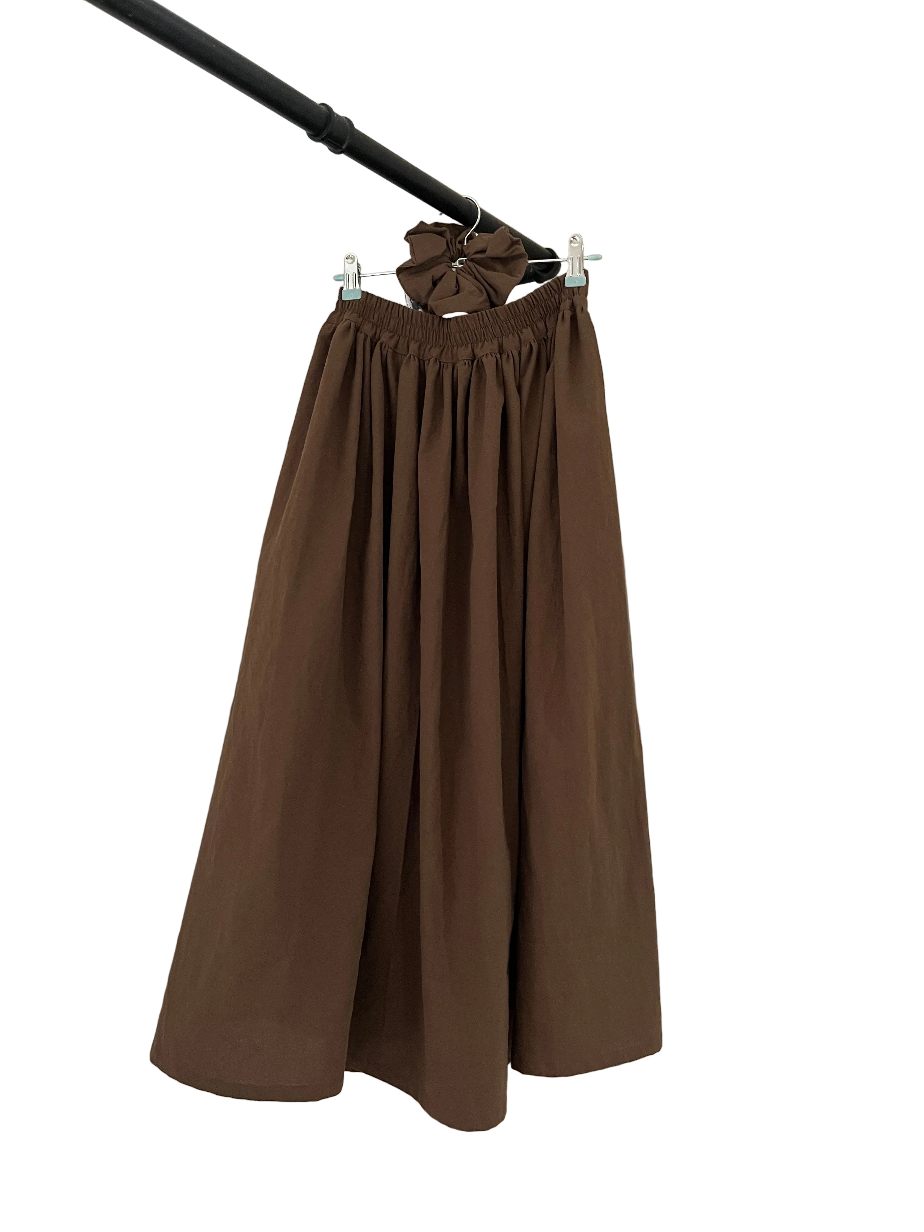 Brown dress on a hanger against a white background