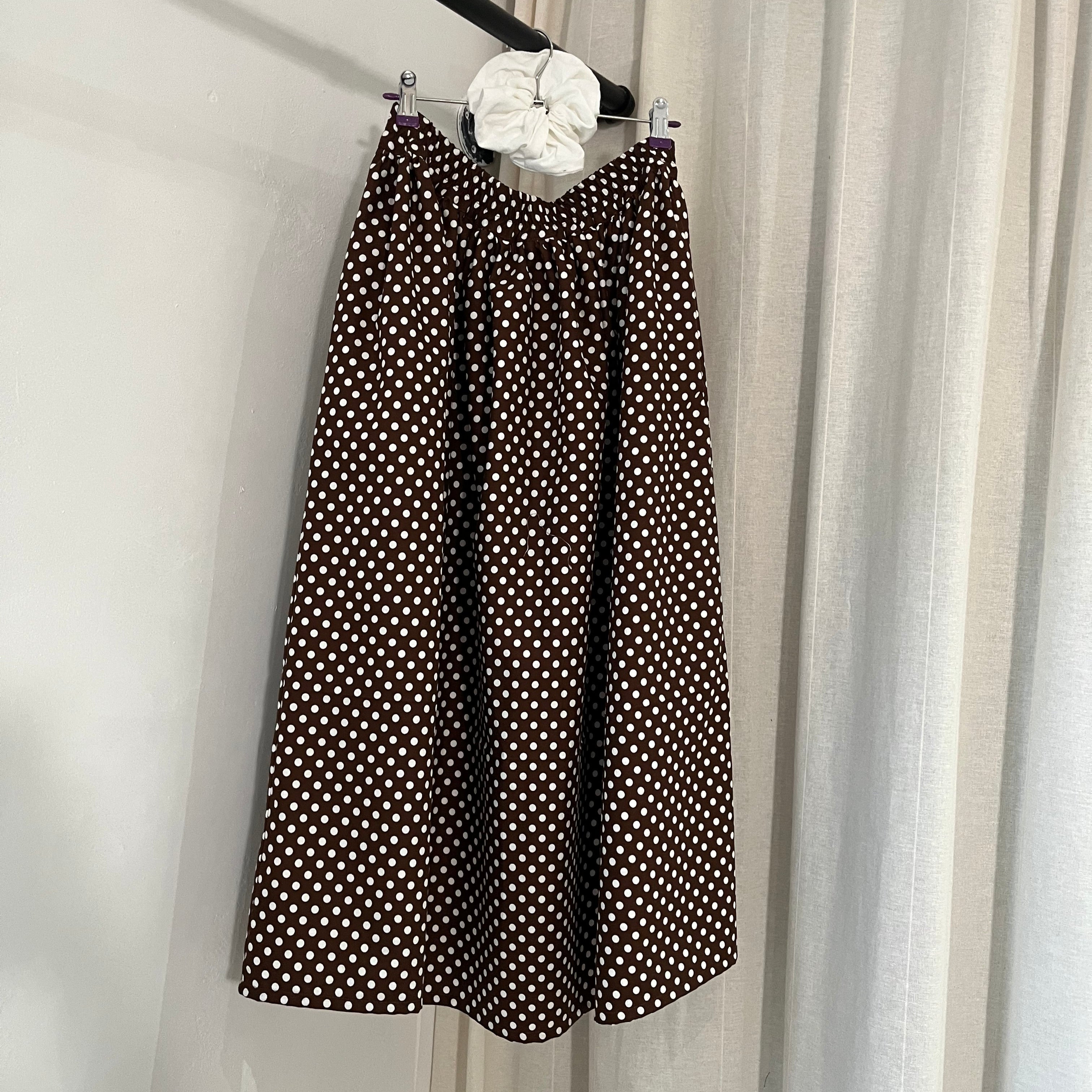 Black polka dot fabric on a stand against a neutral background
