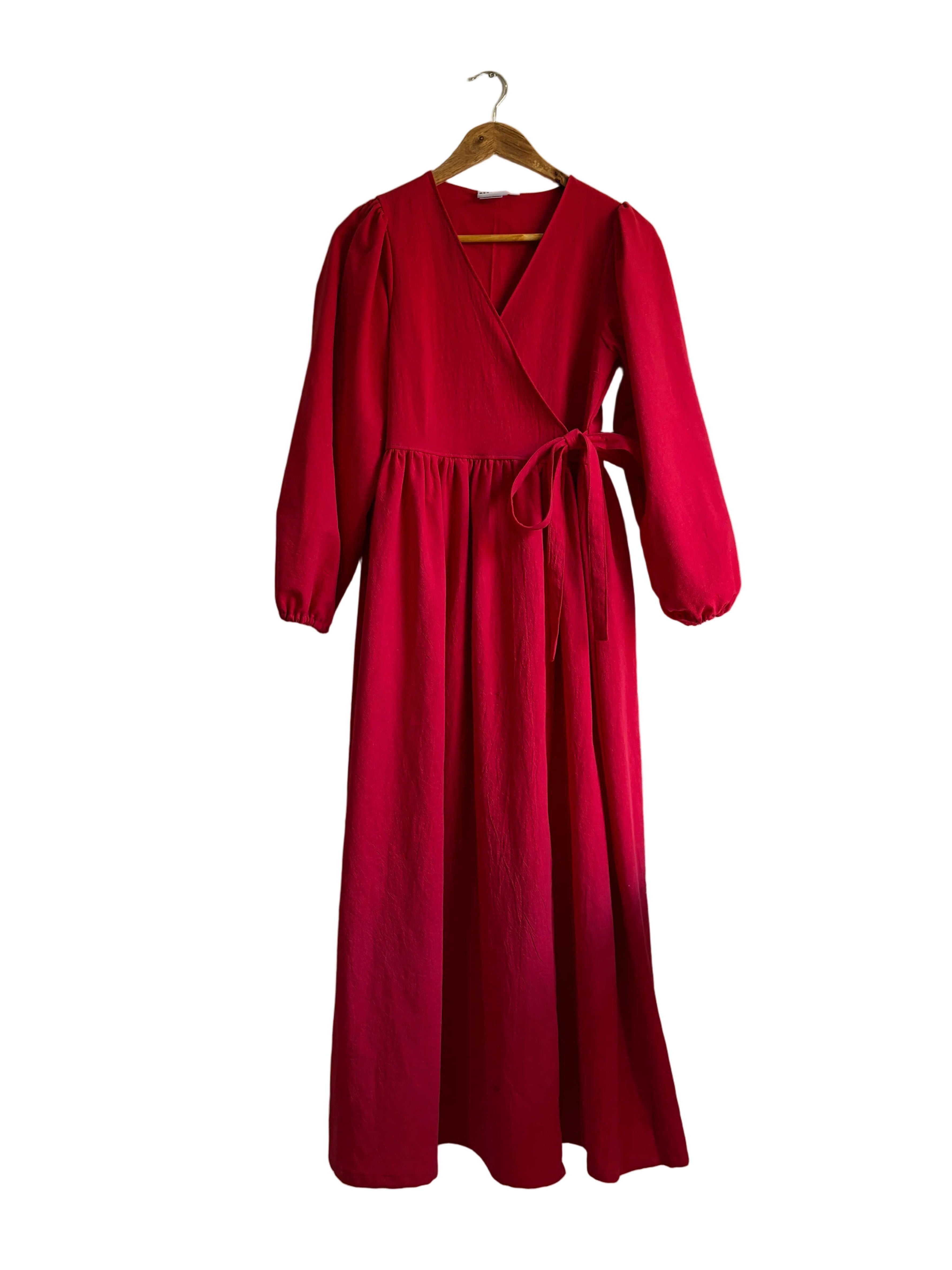 Red dress on a hanger against a white wall