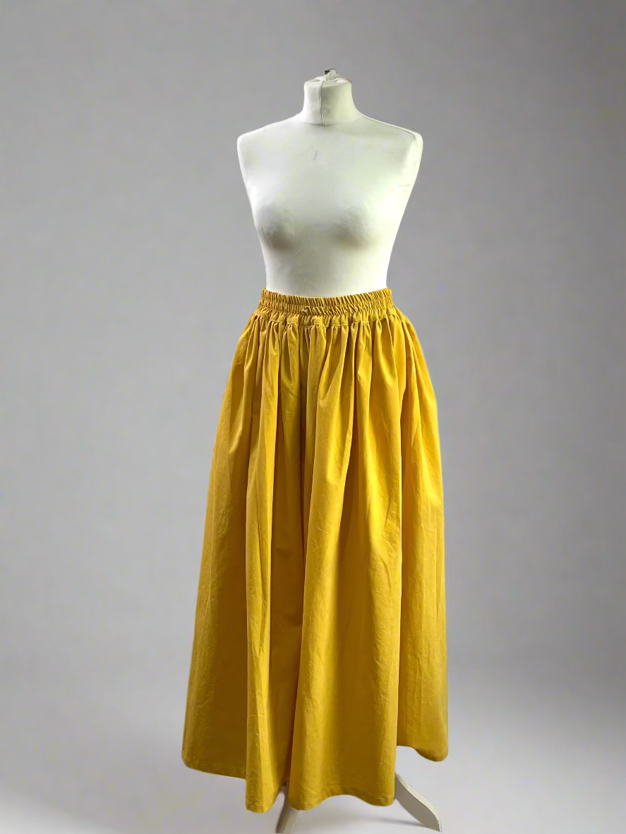 Yellow skirt on a mannequin against a plain wall.