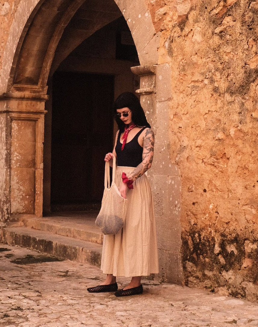 Person standing inside a stone archway with a stone floor.